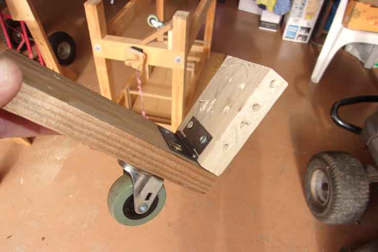 Close up photo of part of the mobile tool bench mechanism showing the hinge and the castor. Detail of the mobile tool base workbench